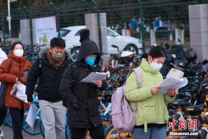 12月24日，2023年全国硕士研究生招生考试正式开考，全国报考人数为474万。图为北京工业大学考点外，考生在进入考场前加紧复习。 <a target=