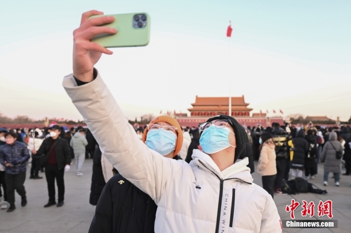 2023年1月1日晨，北京天安门广场举行隆重的升国旗仪式。人们来到天安门广场观看升旗仪式，迎接新年。图为市民拍照留念。 <a target='_blank' href='/'>中新社</a>记者 赵文宇 摄