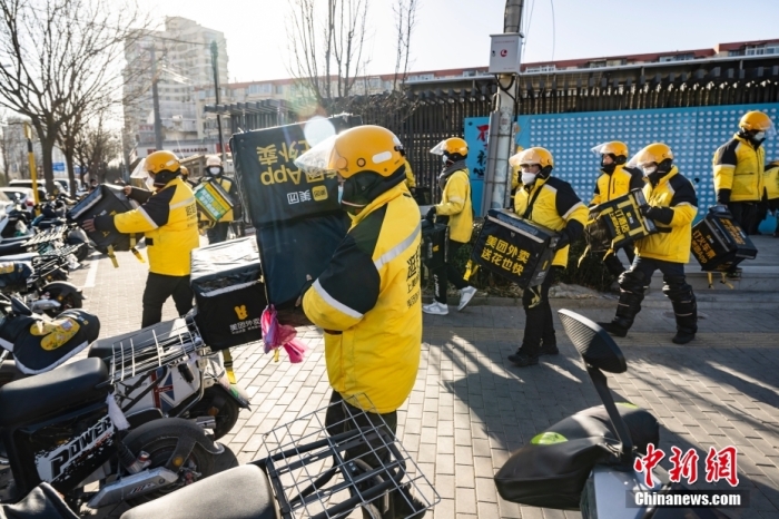 图为外卖送餐员在北京市朝阳区的街头开完早会后投入工作。 <a target='_blank' href='/'>中新社</a>记者 侯宇 摄
