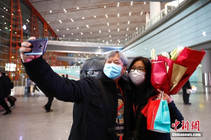 2月6日17时20分，17名香港游客乘CA112航班抵达北京首都国际机场，开启五天的北京之旅。这是内地居民与香港、澳门团队旅游经营活动恢复后，首个由香港出发赴京的旅行团。图为旅行团游客方先生（左）与夫人在北京首都国际机场自拍留念。图/<a target='_blank' href='/'>中新社</a>记者 富田
