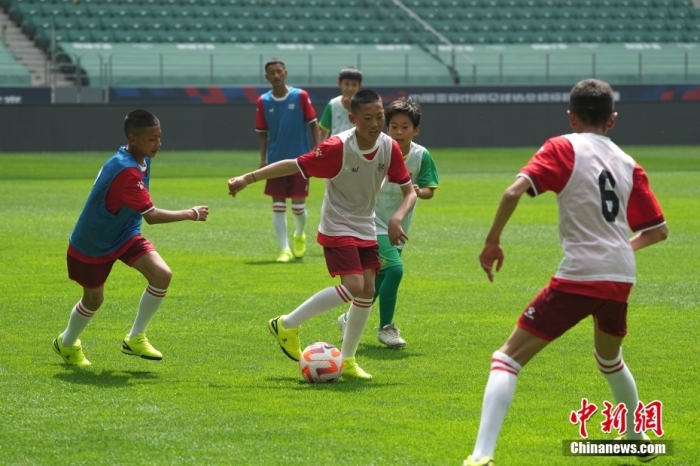 玉树的足球少年和北京国安的小球员一起训练。中新社记者 崔楠 摄