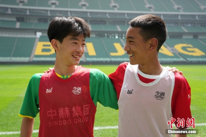 生日在同一天的国安小球员赵云(左)和青海玉树的扎巴江才(右)在场边微笑。中新社记者 崔楠 摄