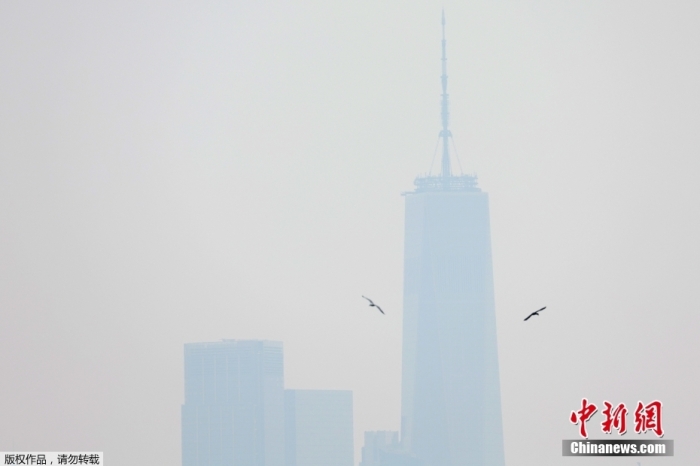 图为当地时间6月6日，位于美国纽约曼哈顿下城的世界贸易中心一号大楼被烟雾笼罩。