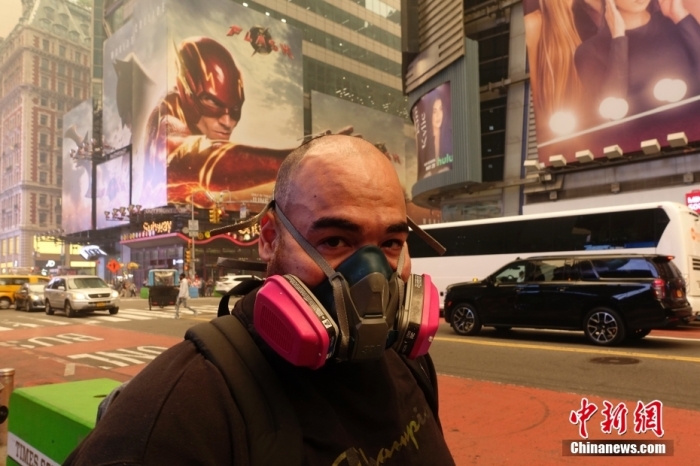 当地时间6月7日，美国纽约时报广场的一位路人佩戴着呼吸过滤器。近日，加拿大野火产生的烟雾蔓延至美国，纽约市出现雾霾，户外民众严密防护。中新社记者 廖攀 摄