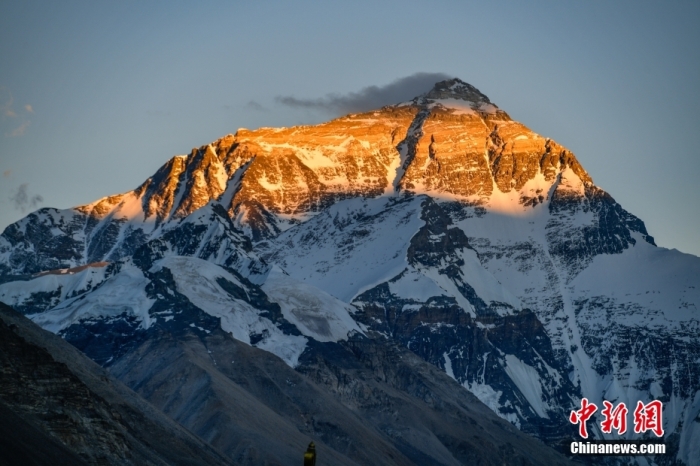 6月20日，位于西藏日喀則市定日縣的世界第一高峰珠穆朗瑪峰景色一日千變，美不勝收。夕陽西下，陽光從山頂緩緩向下暈染，珠峰顯露出“日照金山”的美景。<a target=