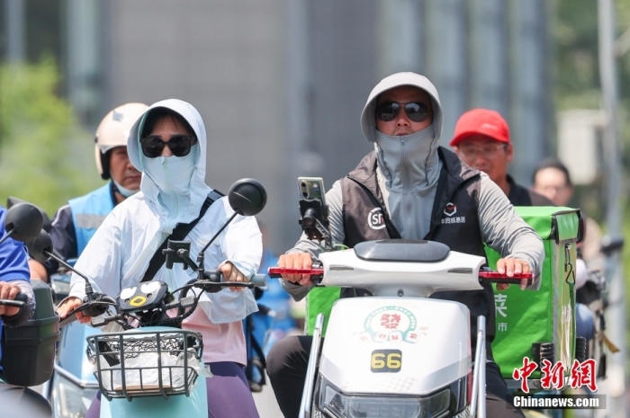 资料图：6月23日，北京迎高温天气，市民在高温下骑车出行。<a target='_blank' href='/'>中新社</a>记者 贾天勇 摄