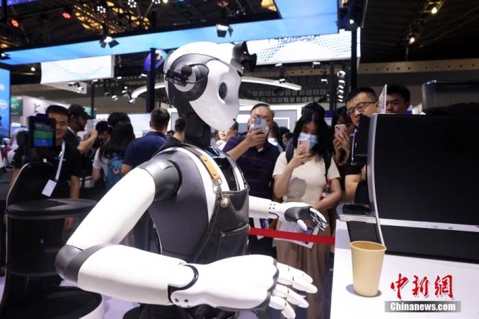 2023世界人工智能大会(WAIC)在上海开幕。图为一款服务机器人吸引观众眼球。
中新社
记者 汤彦俊 摄
