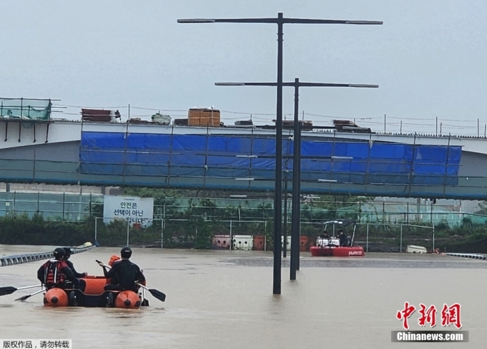 韩国清州，救援人员在一条被洪水淹没的通往地下隧道的道路上寻找幸存者。