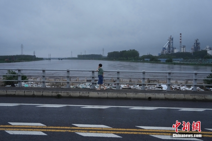 7月31日，北京市房山区，市民步行经过横跨大石河的琉璃河桥。<a target='_blank' href='/'>中新社</a>记者 崔楠 摄