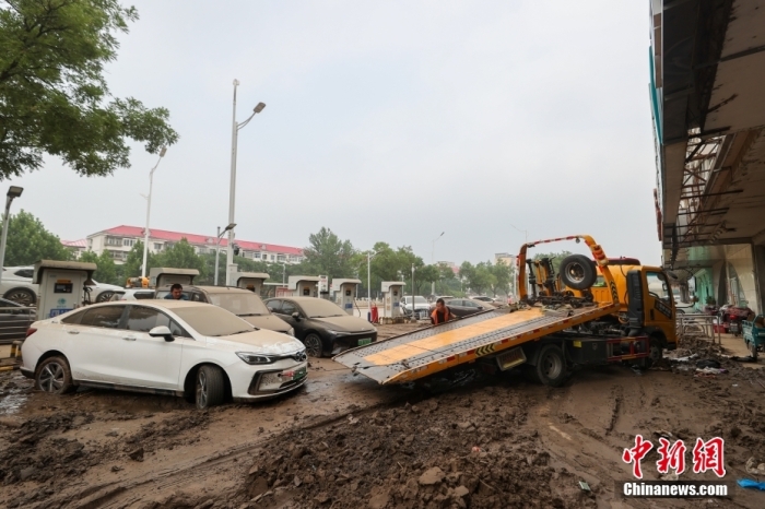 8月3日，北京市门头沟区，救援拖车在将一辆泡水的小轿车从淤泥中拉出。<a target='_blank' href='/'>中新社</a>记者 贾天勇 摄
