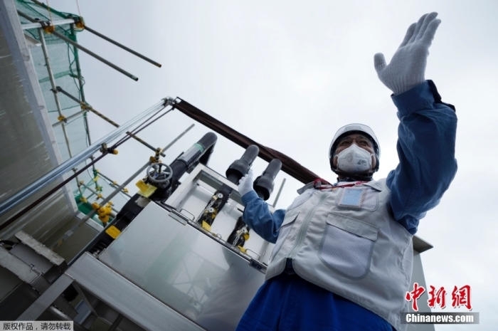 资料图：东京电力公司官员介绍提取经稀释处理的放射性废水样本的设施。图片来源：美联社
