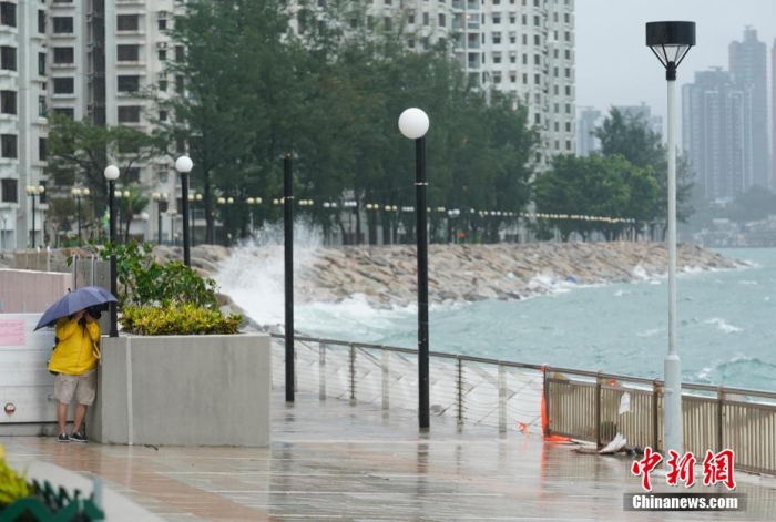 图为香港岛东部杏花邨海滨，一位市民冒着风雨拍摄台风景象。记者 侯宇 摄