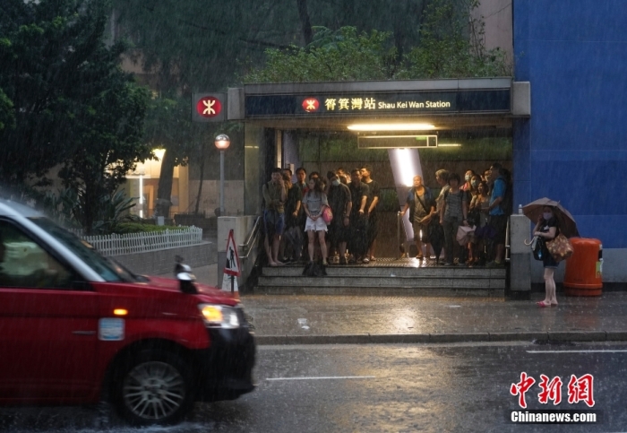 9月8日，自7日夜间起长时间持续的强降雨对香港特别行政区多地造成不同程度的浸水、小型泥石流等灾害。图为市民在筲箕湾地铁站出口避雨。中新社记者 侯宇 摄