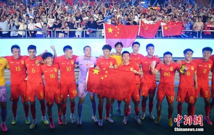 9月27日，杭州第19届亚运会男足前16名决赛在黄龙体育中心体育场举行。中国队1比0胜卡塔尔队，挺进八强。图为中国队队员与看台上的球迷合影。中新社记者 王刚 摄