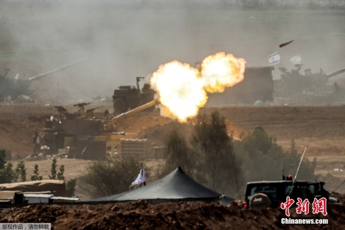资料图：以色列军队在以色列南部与加沙边界附近发射炮弹。