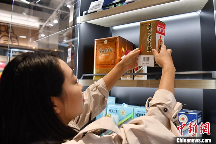 11月1日，四川成都，一名消费者在超市选购贵州茅台酒。10月31日晚间，贵州茅台发布公告，于11月1日起，调整53%vol贵州茅台酒(飞天、五星)出厂价格，平均上调幅度约为20%。 中新社记者 张浪 摄